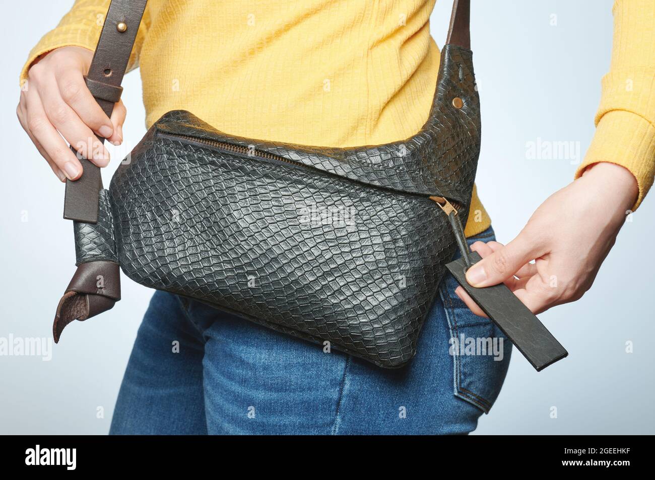Borsa chiusa in pelle nera su casual donna vita isolato Foto Stock