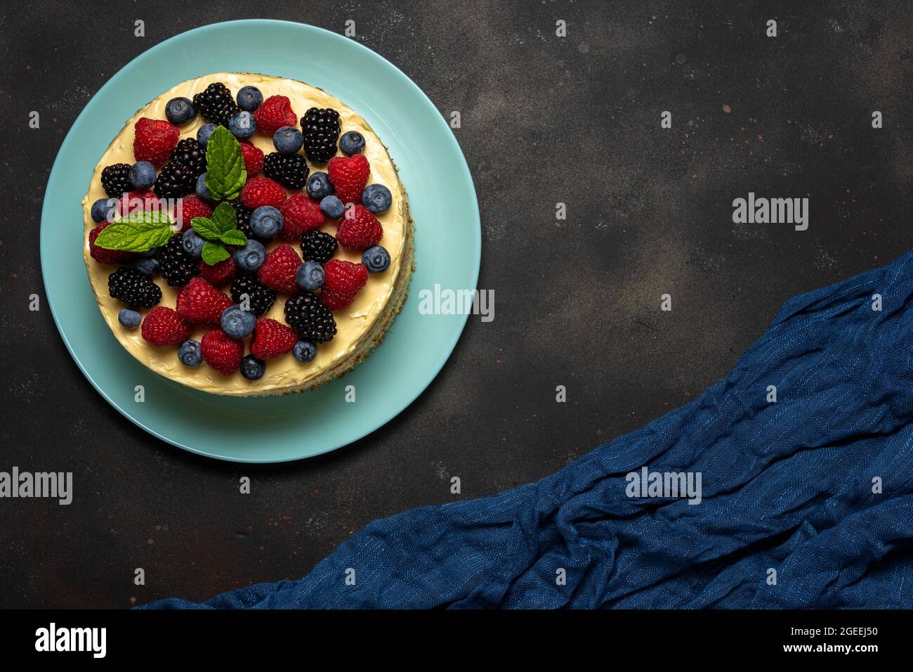 Torta fatta in casa con frutti di bosco freschi su sfondo scuro. Foto Stock
