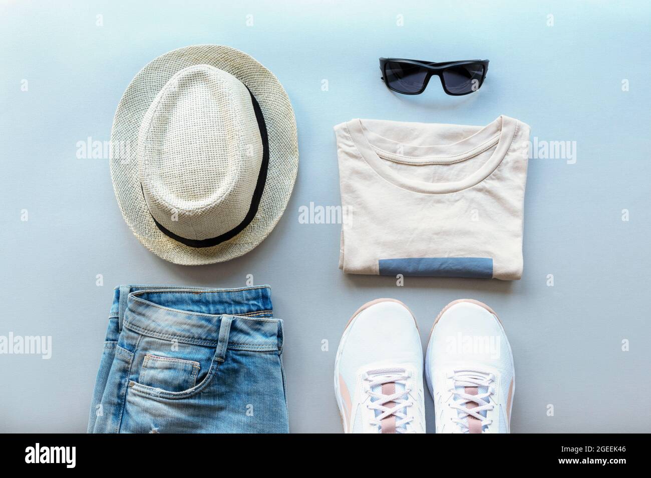 Donna moda estate piatta posare con bei abiti casual elegante e accessori su sfondo grigio. Vista dall'alto Foto Stock