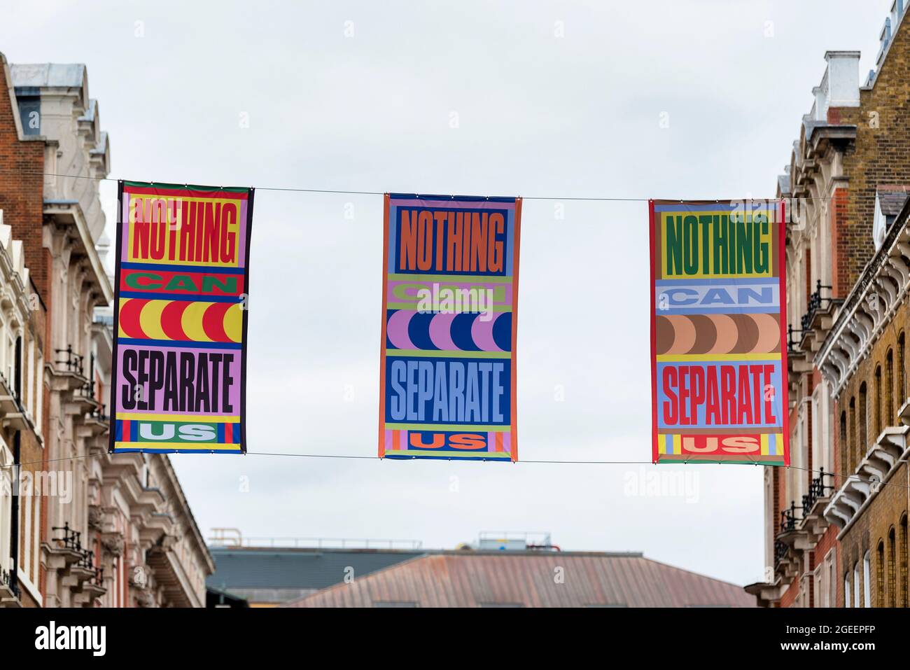 Londra, Regno Unito. 10 agosto 2021. Striscioni appesi a King Street, Covent Garden parte di un'installazione d'arte 'Nothing CAN separation us' dell'artista londinese Lakwena. Bandiere sulla trafficata King Street e Henrietta Street blasonate con messaggi positivi come Londra celebra l'inizio dell'estate e emerge dall'ultima fase di Lockdown e Floral Street con paletti colorati dipinti a mano. (Credit Image: © Dave Rushen/SOPA Images via ZUMA Press Wire) Foto Stock