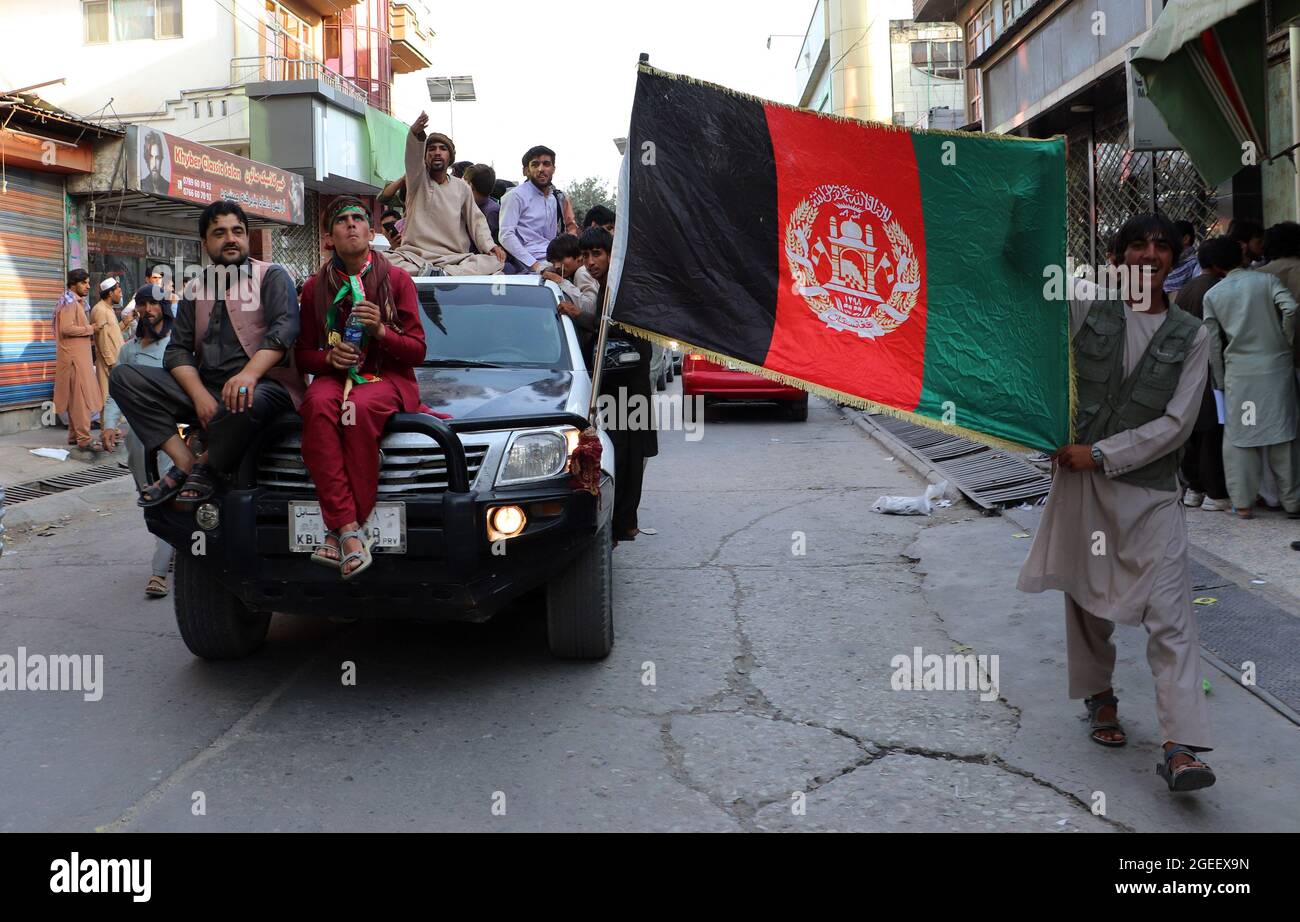 La gente porta la bandiera nazionale a una protesta tenuta durante la Giornata dell'Indipendenza afgana a Kabul, Afghanistan, giovedì 19 agosto 2021, in occasione dell'acquisizione militare dell'Afghanistan da parte dei talebani. Photo by Bashir Darwish/UPI Credit: UPI/Alamy Live News Foto Stock