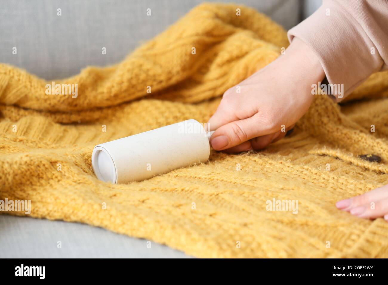 Donna pulizia maglia maglione con rullo pelucchi, closeup Foto stock - Alamy