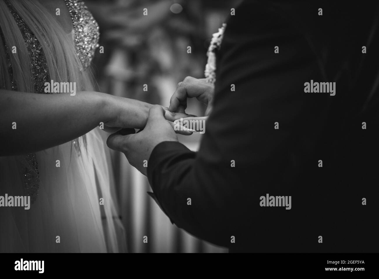 Foto in scala di grigi della cerimonia di scambio di anelli durante il matrimonio Foto Stock