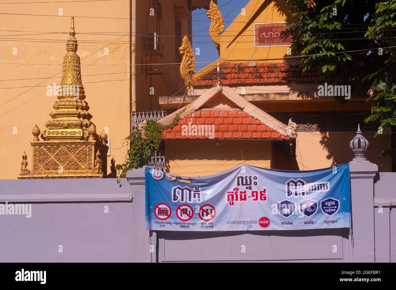 Un banner COVID - 19, scritto in Khmer script, pende fuori da Wat Langka durante la pandemia del coronavirus. Phnom Penh, Cambogia. 18 agosto 2021. © Kraig Lieb Foto Stock