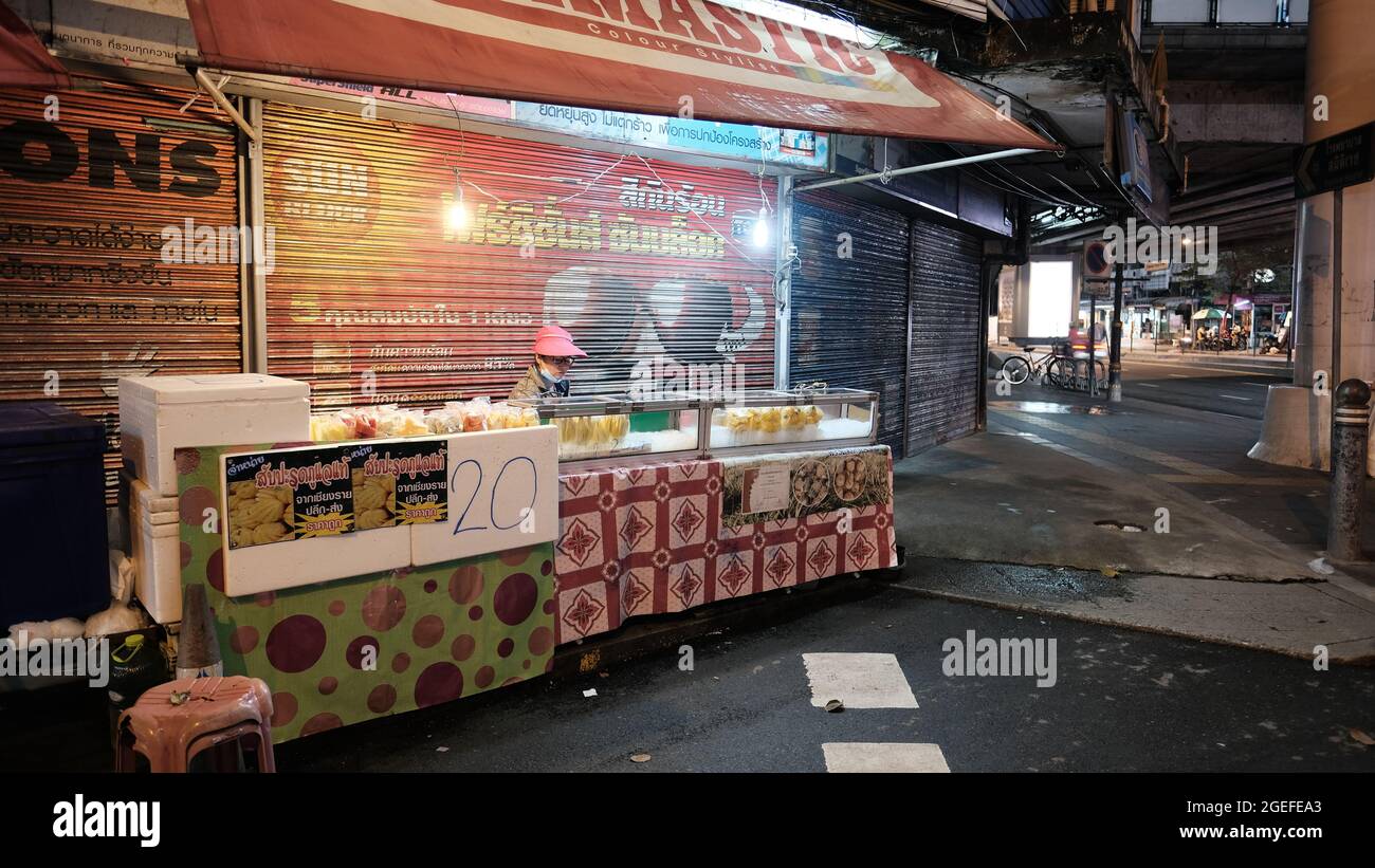 Lady con cappello rosso che vende frutta fresca a fette al Sukhumvit Soi 38 Street Food Court Thong lo Bangkok Thailandia Foto Stock