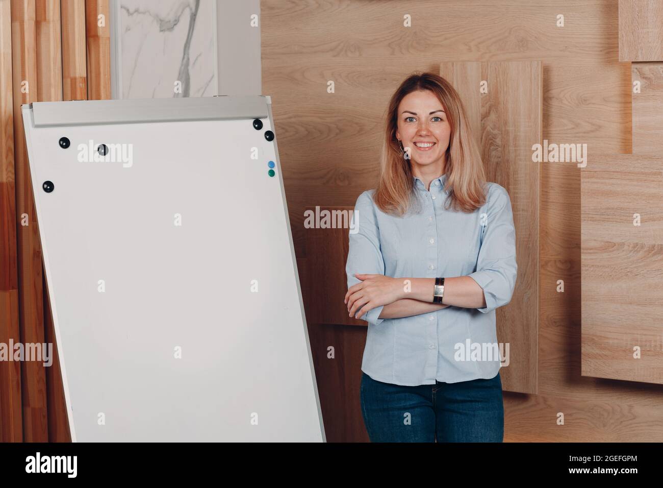 Donna d'affari giovane adulto vettura si alza in ufficio con vuoto modello lavagna bianca lavagna a fogli mobili Foto Stock