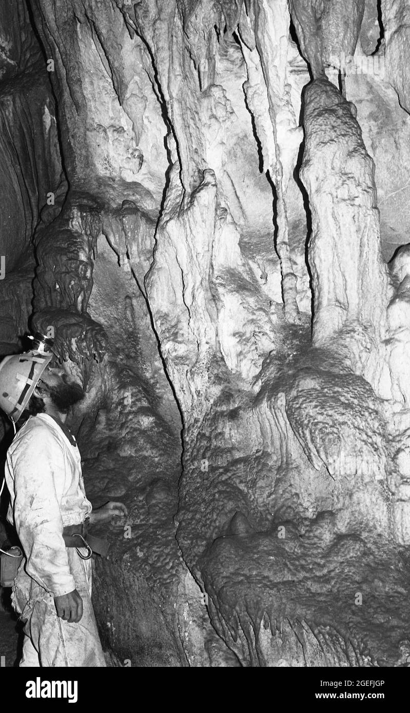 YASS, AUSTRALIA, CIRCA 1982: Un caver sconosciuto ispeziona le formazioni alla Grotta di Punchbowl vicino a Yass. Foto Stock