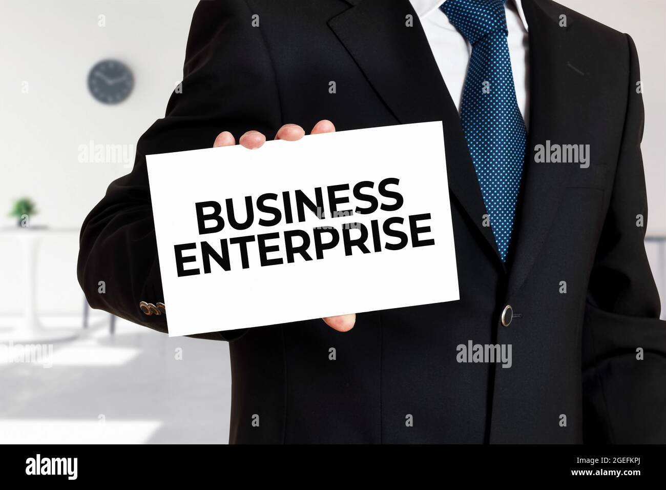L'uomo d'affari tiene una scheda con l'impresa di affari del messaggio. Foto Stock