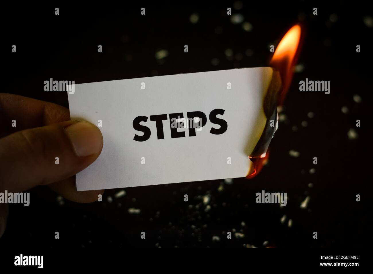 punti brucianti, mano umana che tiene la parola punti scritti su una carta che brucia con fiamma e ceneri su uno sfondo nero, concetto Foto Stock