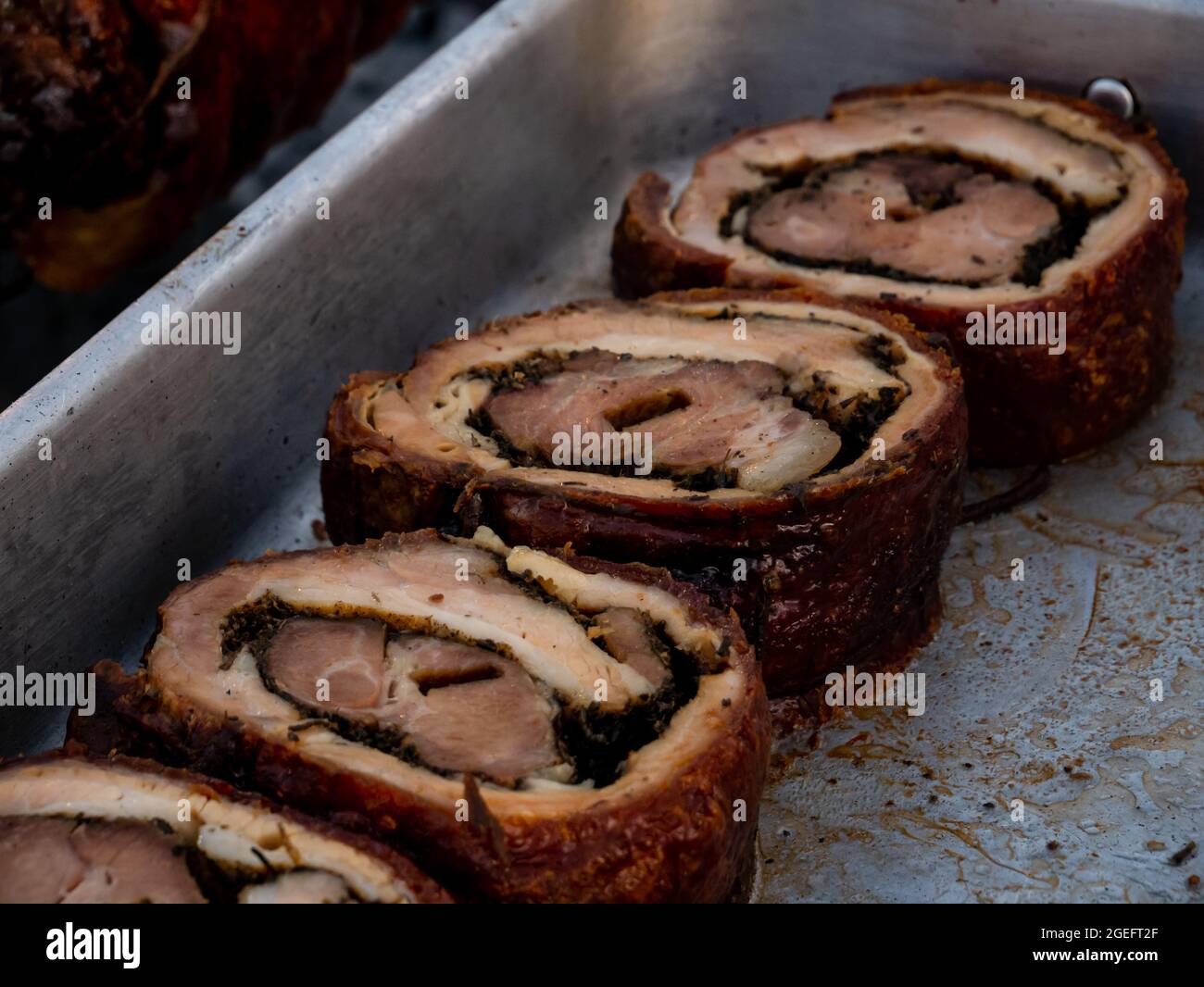 rotolo di maiale arrosto affettato in un vassoio di metallo Foto Stock