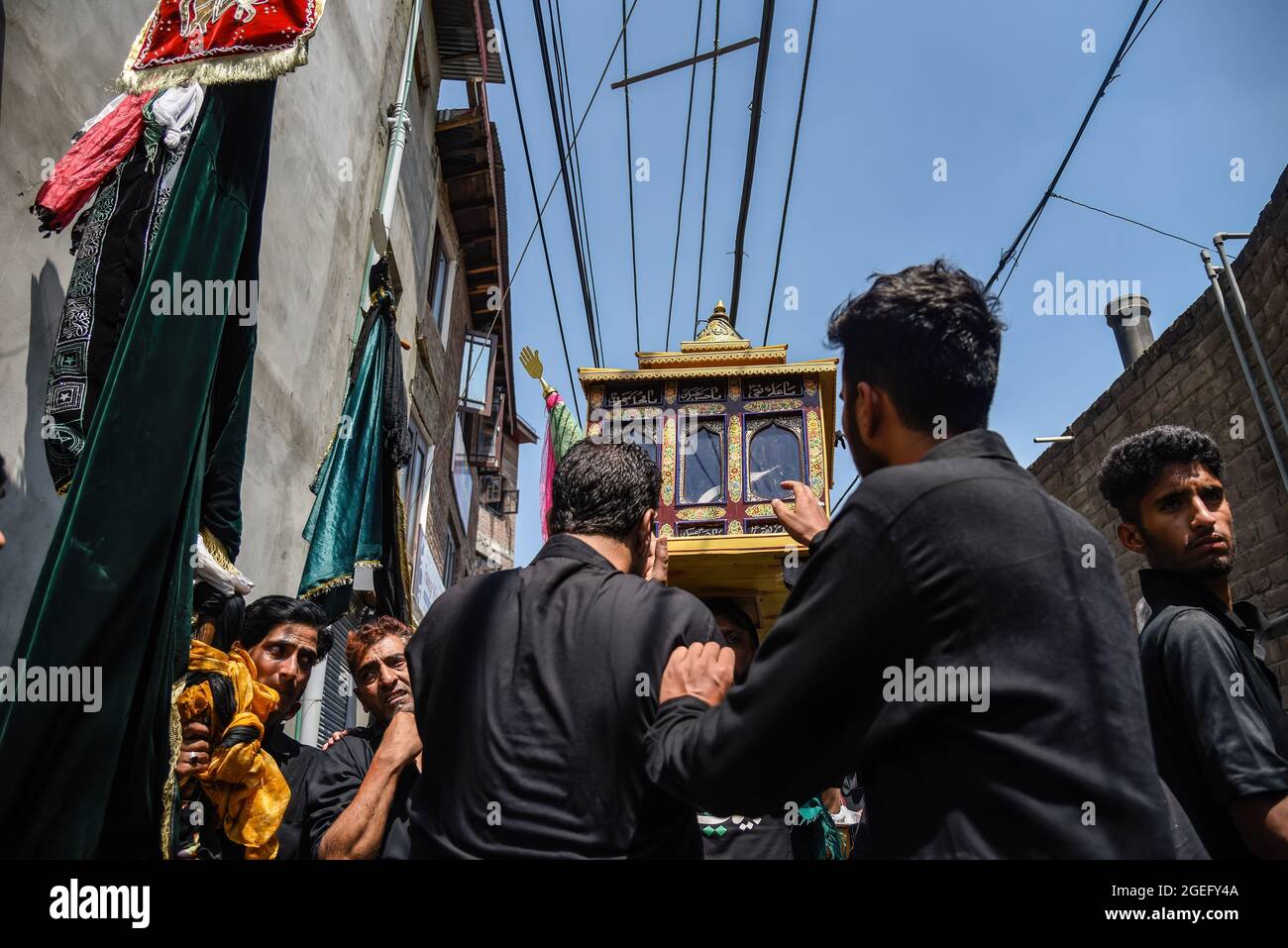 I musulmani di Kashmiri Shia toccano una cassa di vetro contenente il Sacro Corano durante l'Ashura a Srinagar. I credenti musulmani sciiti offrono preghiere, picchiano le loro casse mentre cantano slogan religiosi e distribuiscono cibo religioso chiamato 'nazri', mentre reagiscono aspetti dell'uccisione di Imam Hussain e dei suoi 72 seguaci nel 680AD a Karbala su Ashura (il decimo di Muharram), nell'attuale Iraq, Dagli eserciti molto più grandi dello Yazid. Imam Hussain è venerato tra gli sciiti come il 'Signore dei Martiri', la cui resistenza e la volontà di morire per la sua fede religiosa di fronte alla forza schiacciante è venerata Foto Stock