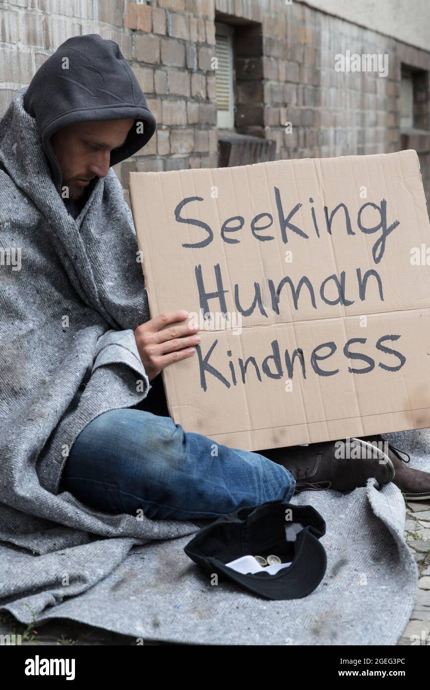 Senza casa Lonely povero uomo con cartone alla ricerca di gentilezza Foto Stock