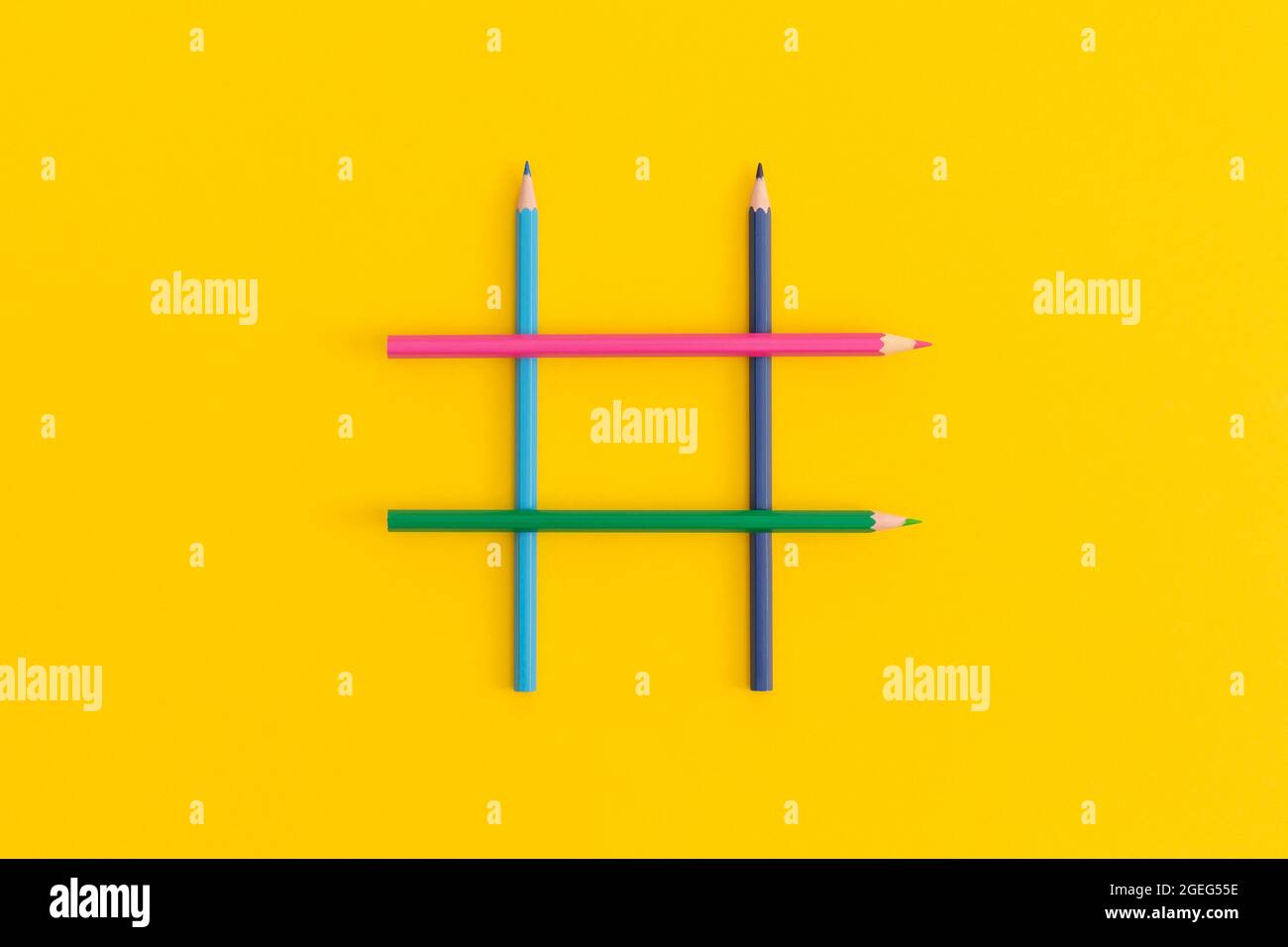 Hashtag segno fatto di matite colorate su sfondo giallo Foto Stock