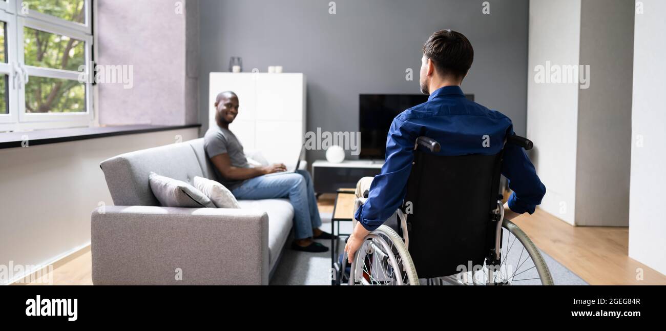 Uomo disabili in sedia a rotelle. Coppia gay che parlano Foto Stock