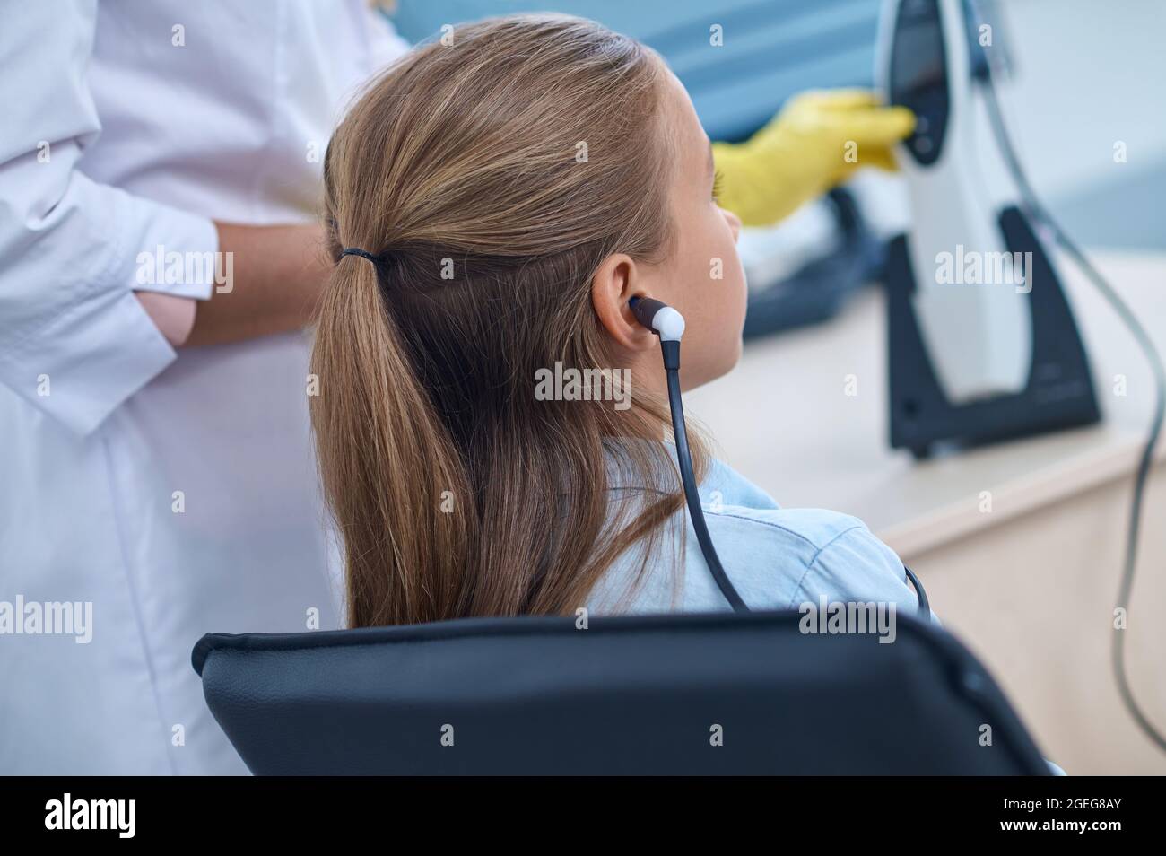 Vista posteriore dell'auricolare della ragazza nell'ufficio degli otolaringologi Foto Stock