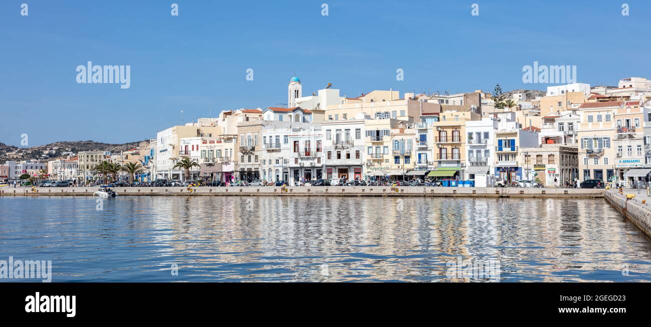 Isola di Syros, Cicladi, Grecia. Maggio 27, 2021. Ermoupolis paesaggio urbano, edifici lungomare sulla costa, vista dal mare. Giorno estivo soleggiato, blu s Foto Stock