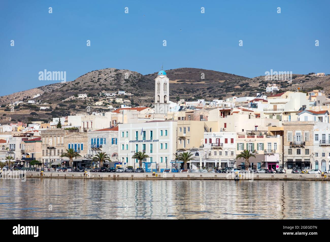 Isola di Syros, Cicladi, Grecia. Maggio 27, 2021. Ermoupolis paesaggio urbano, edifici lungomare sulla costa, vista dal mare. Giorno estivo soleggiato, blu s Foto Stock