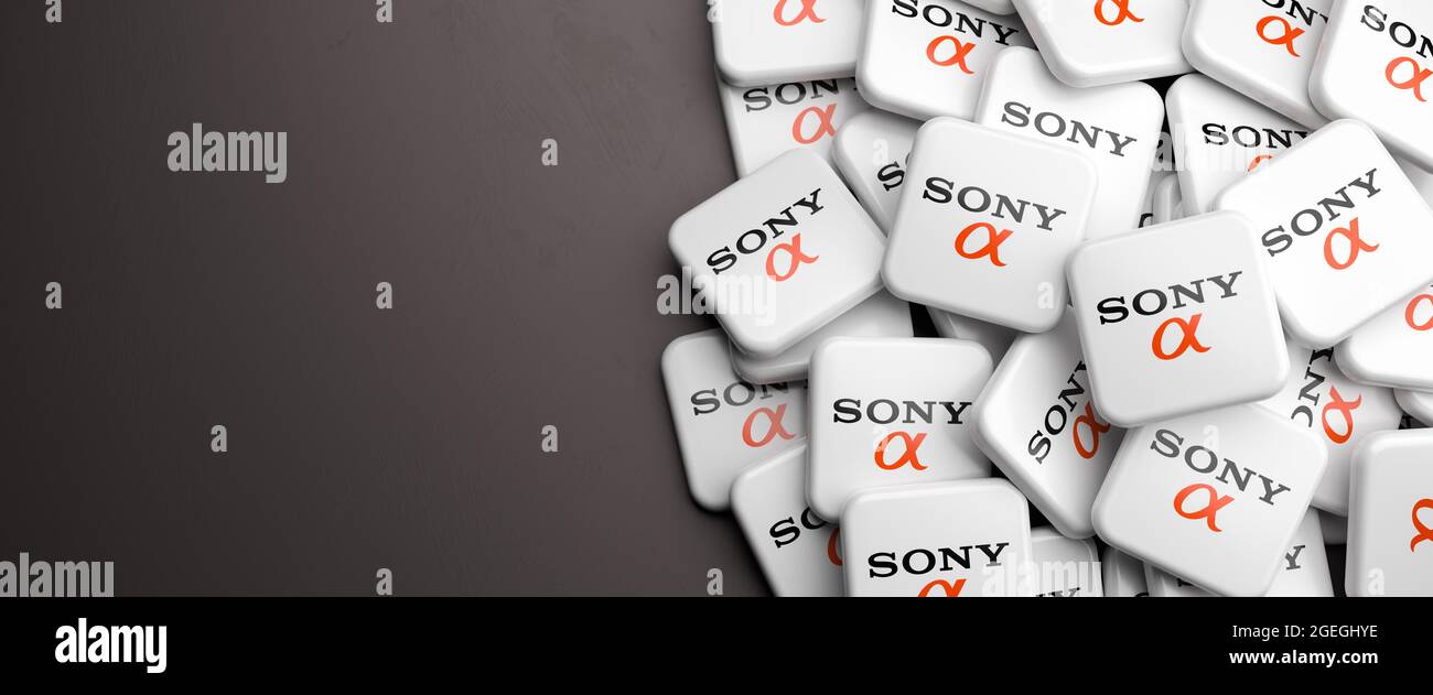 Logo del sistema di telecamere giapponese Sony Alpha su un mucchio su un tavolo. Spazio di copia. Formato banner Web. Foto Stock