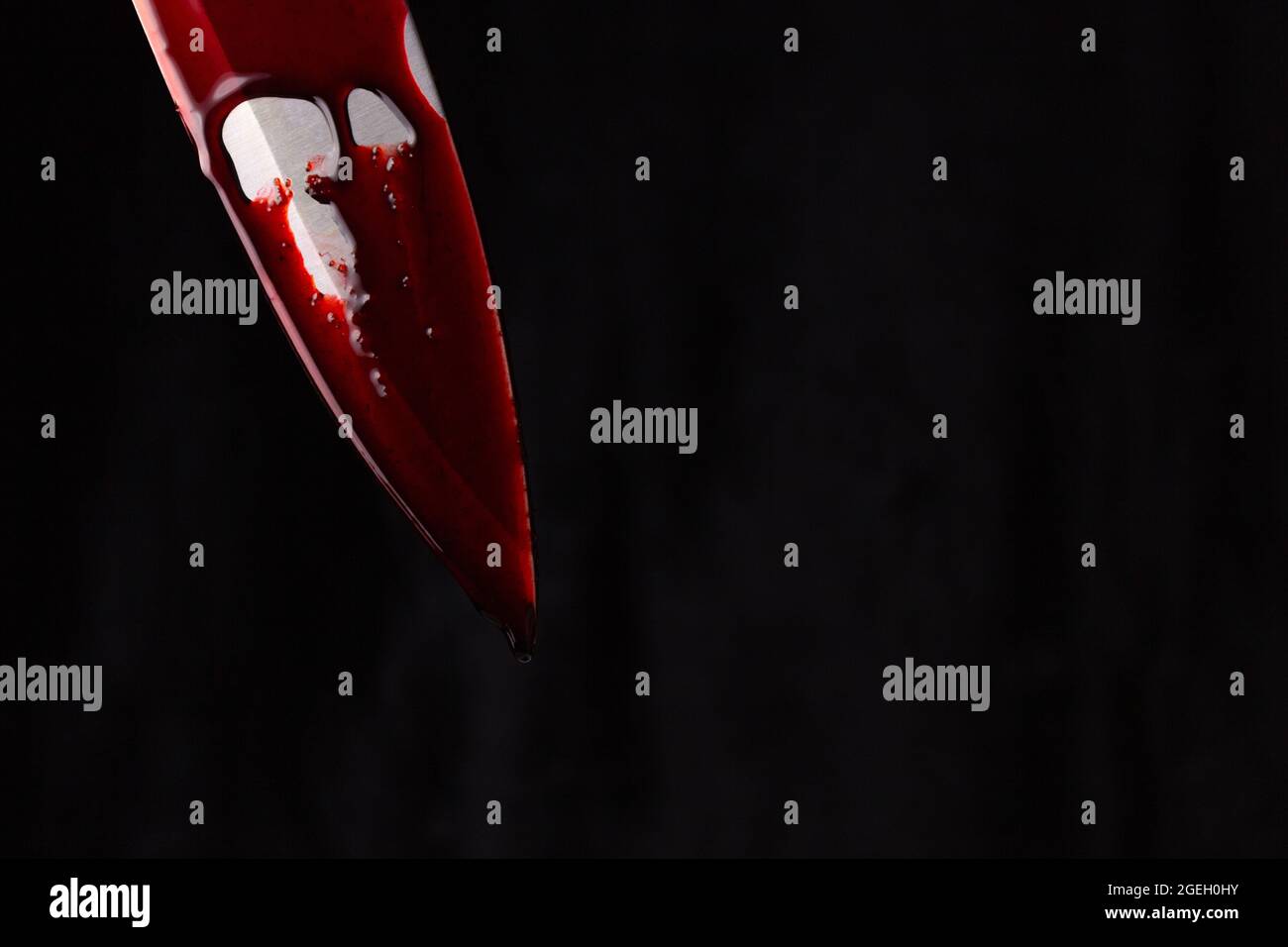 Un coltello sanguinante su sfondo nero. Il concetto di omicidio, criminalità. Foto Stock