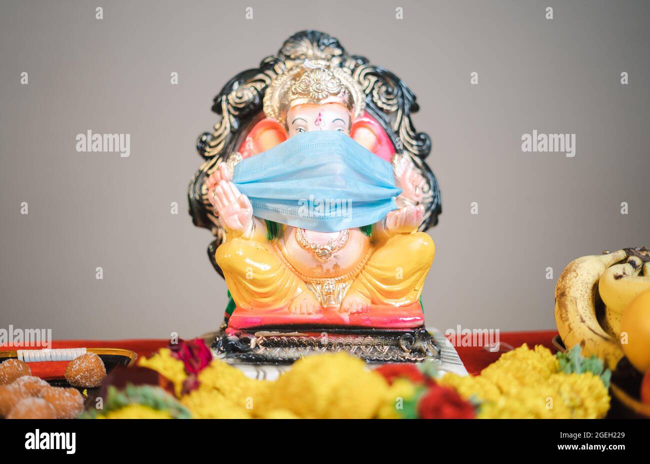 Ganesha o ganapati idol con maschera medica per le celebrazioni del festival durante coronavirus covid pandemic per incoraggiare la gente a indossare la maschera Foto Stock