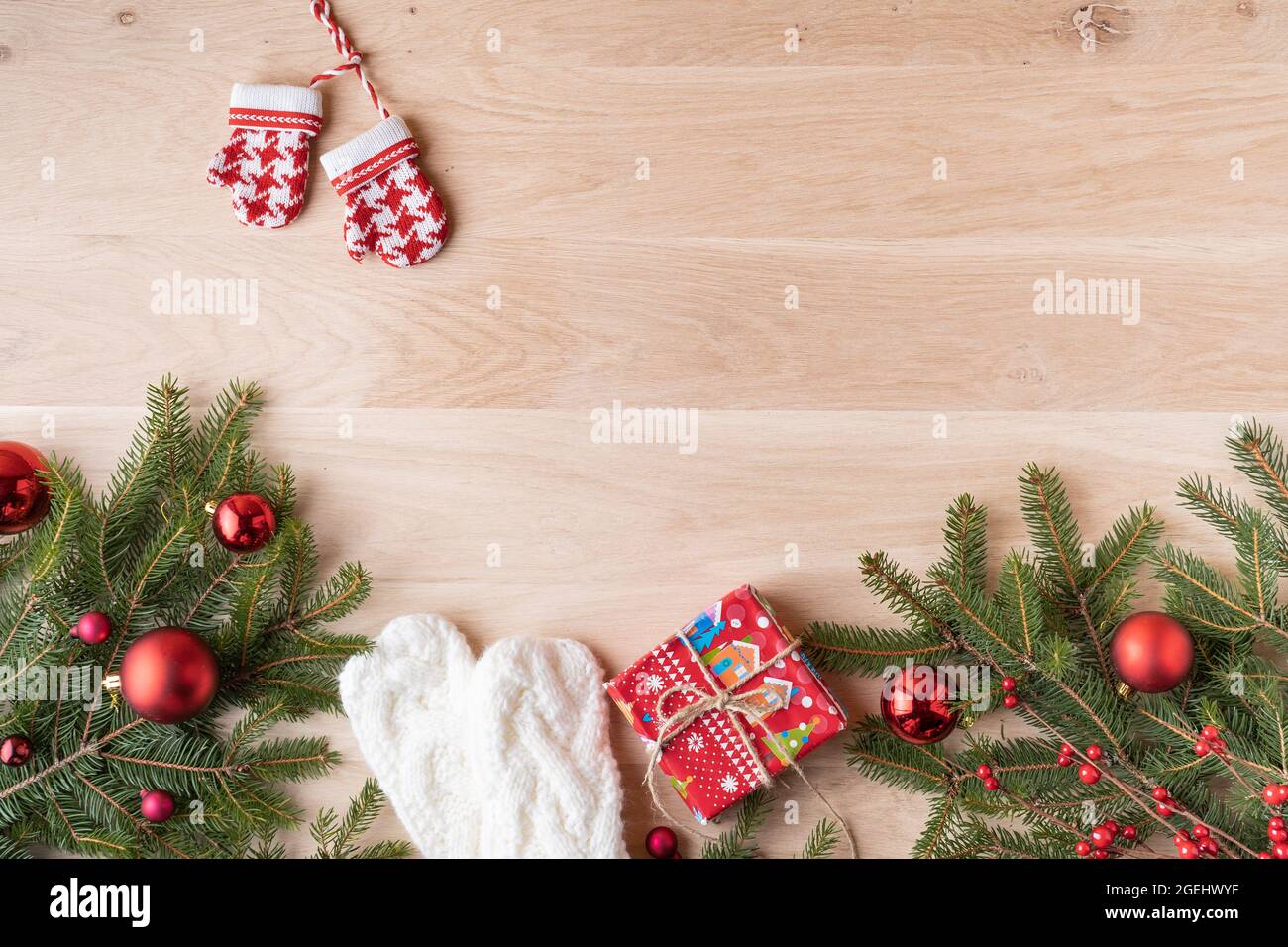 Composizione di Natale. Regali di Natale, rami di pino, giocattoli su sfondo di legno. Disposizione piatta, vista dall'alto. Foto Stock