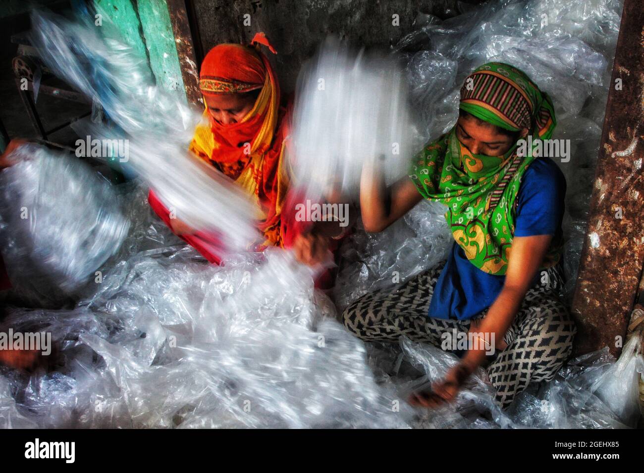 Dhaka, Bangladesh . 20 ago 2021. Dhaka, Bangladesh, 20 agosto 2021: Le lavoratrici di Kagrangichar raccolgono e separano i sacchi monouso da riutilizzare in una fabbrica di politene. Credit: Maruf Rahman /Eyepix Group/Alamy Live News Credit: Eyepix Group/Alamy Live News Foto Stock