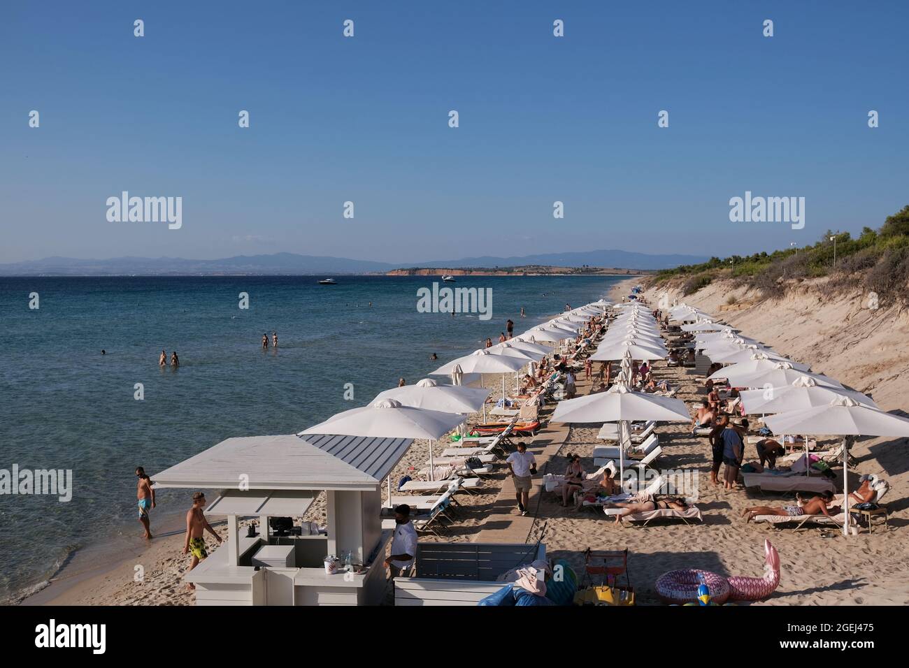 Halkidiki, Grecia - 16 agosto 2021 : molti ombrelloni e lettini usati dai  turisti che si godono il sole sulla spiaggia di sani Chalkidiki in N Foto  stock - Alamy