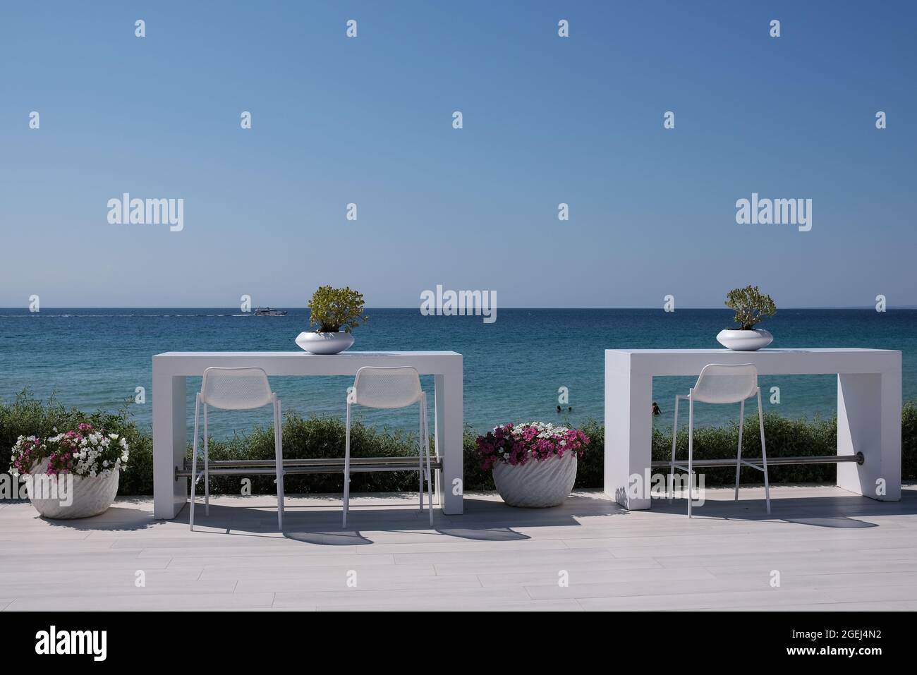 Un bel tavolo bianco decorato e sedie in un bar all'aperto di fronte al mare egeo in Chalkidiki Grecia Foto Stock