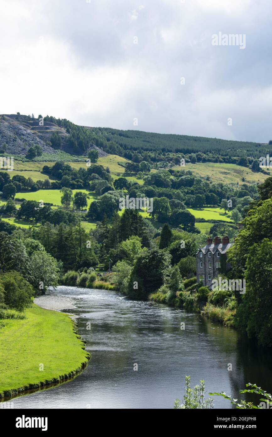 Valle di Dee, Galles settentrionale. Bel paesaggio di campi rurali e terreni agricoli con il fiume che scorre. Scatto verticale con spazio di copia. Foto Stock