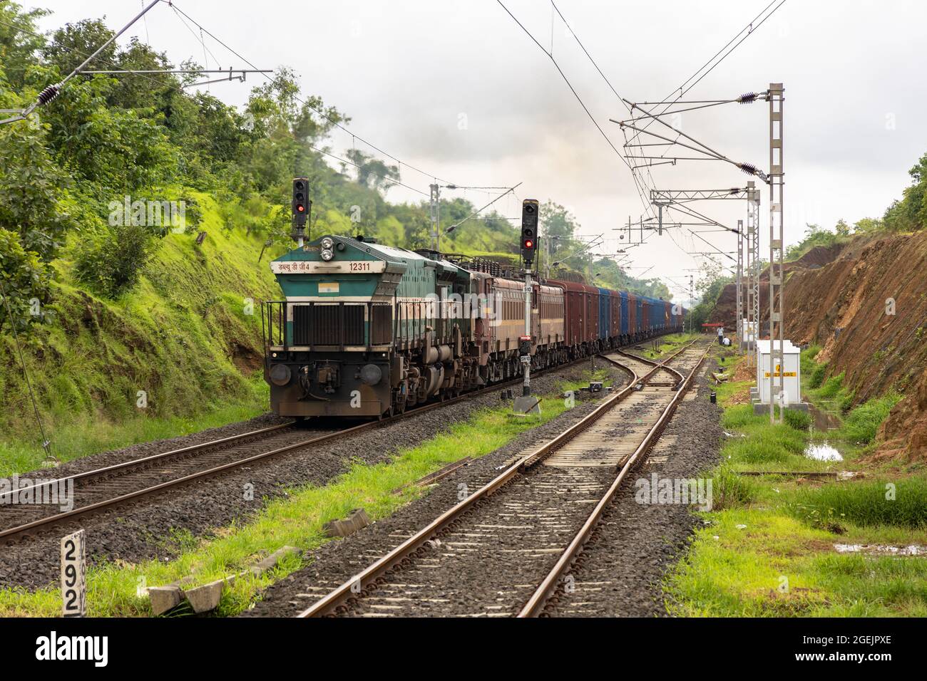 Treno merci guidato dalla locomotiva diesel WDG-4 e due locomotive elettriche morte alla stazione di Vaibhavwadi Road sulla ferrovia di Konkan. Foto Stock