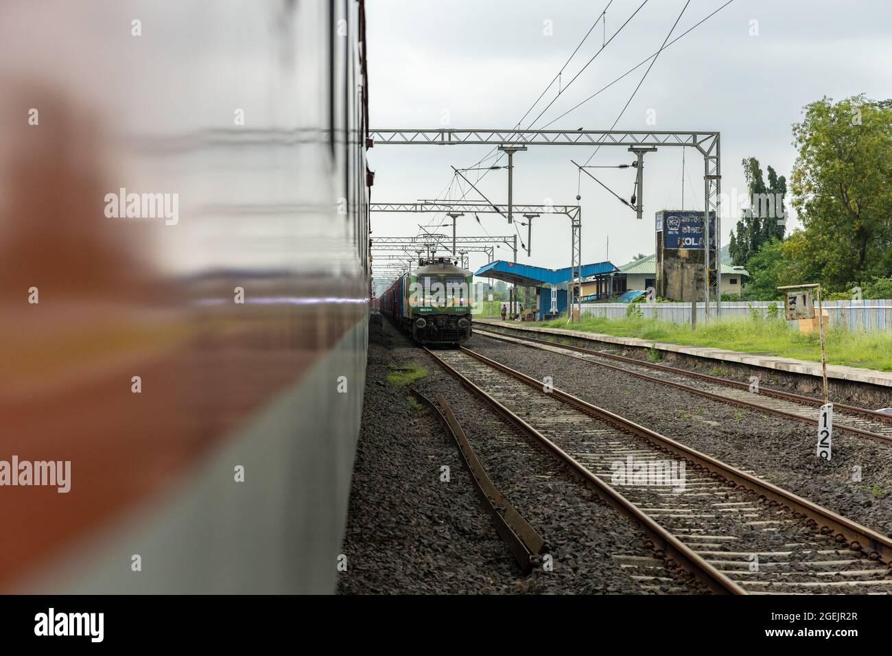 Treno merci con locomotiva elettrica WAG-9HC alla stazione ferroviaria di Kolad dopo parziale elettrificazione della Ferrovia di Konkan. Foto Stock