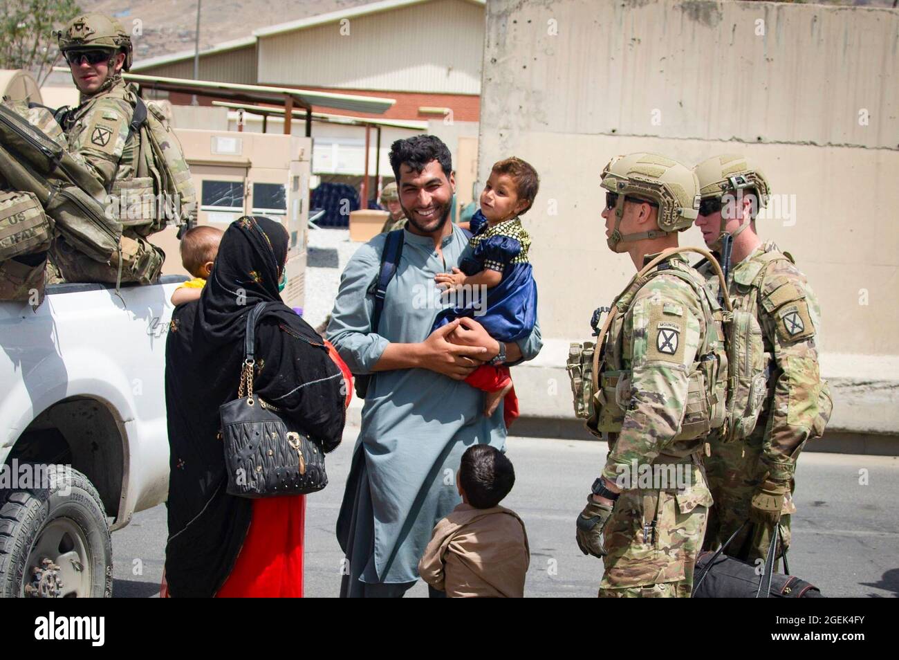 I soldati con la decima Divisione montagna scortano gli evacuati all'Aeroporto Internazionale Hamid Karzai, Afghanistan, 20 agosto. I membri del servizio degli Stati Uniti stanno assistendo il Dipartimento di Stato con un'operazione DI evacuazione non combattente (NEO) in Afghanistan. (STATI UNITI Foto del corpo marino di CPL. Davis Harris) Foto Stock