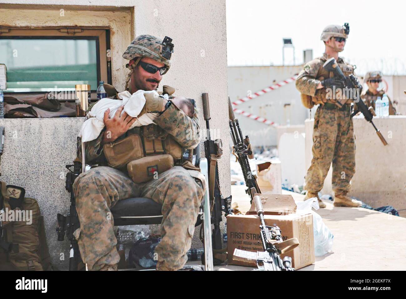 Kabul, Afghanistan. 20 ago 2021. Un marines degli Stati Uniti assegnato alla 24a unità di spedizione marina, conforta un bambino durante l'evacuazione dei non-combattenti all'Aeroporto Internazionale Hamid Karzai, parte dell'operazione Allees Refuge 20 agosto 2021 a Kabul, Afghanistan. Credit: Planetpix/Alamy Live News Foto Stock