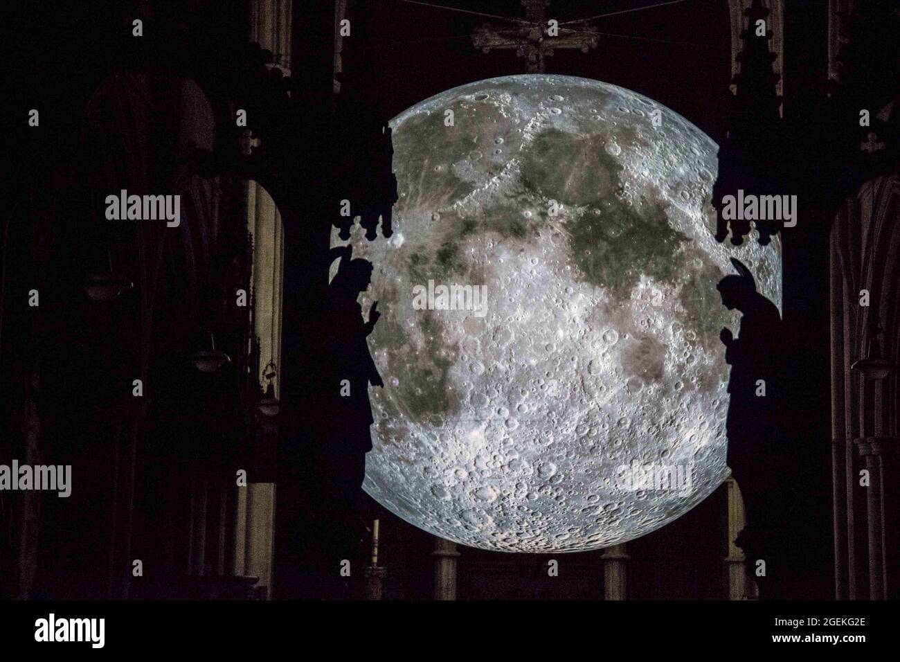 Londra UK 20 ago 2021 Angel Gabriel (L) e Mary (R) hanno scolpito contro l'artista britannico Luke Jerram Moon. Come parte del Kensington Chelsea Festival .Museum of the Moon è un'opera d'arte itinerante dell'artista britannico Luke Jerram. Con un diametro di sette metri, la luna presenta immagini NASA dettagliate a 120 dpi della superficie lunare. Mostra alla chiesa di San Giovanni Battista in Shepherd's Bush. Paul Quezada-Neiman/Alamy Live News Foto Stock