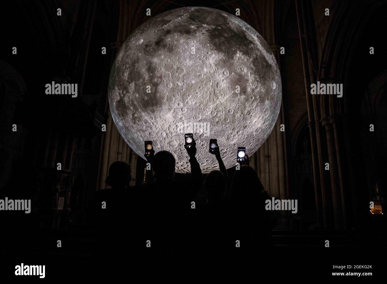 Londra UK 20 ago 2021 Angel Gabriel (L) e Mary (R) hanno scolpito contro l'artista britannico Luke Jerram Moon. Come parte del Kensington Chelsea Festival .Museum of the Moon è un'opera d'arte itinerante dell'artista britannico Luke Jerram. Con un diametro di sette metri, la luna presenta immagini NASA dettagliate a 120 dpi della superficie lunare. Mostra alla chiesa di San Giovanni Battista in Shepherd's Bush. Paul Quezada-Neiman/Alamy Live News Foto Stock