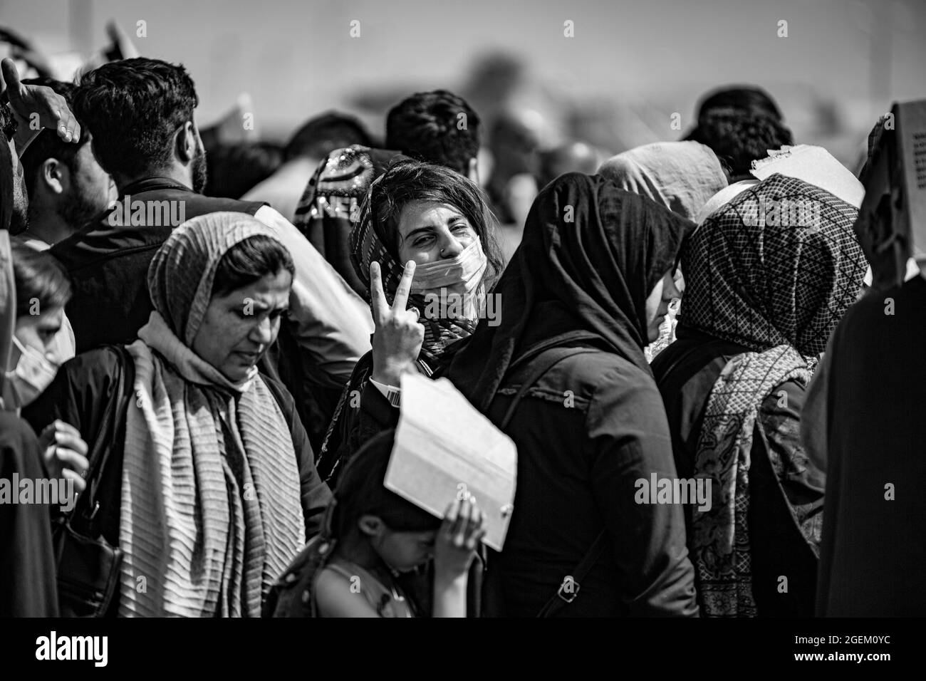 Un evacuato ha un segnale di pace dopo essere stato manifestato per un volo all'Aeroporto Internazionale Hamid Karzai, 19 agosto. I membri del servizio degli Stati Uniti stanno assistendo il Dipartimento di Stato con un'operazione di evacuazione non combattente (NEO) in Afghanistan. (STATI UNITI Foto del corpo marino di 1° Ora. Mark Andries) Foto Stock