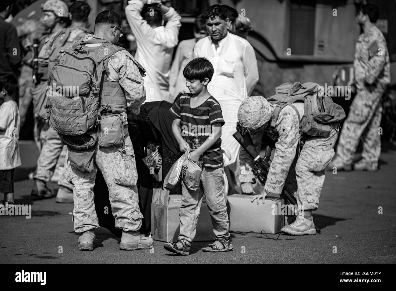 Marines assegnato a Special Purpose Marine Air Ground Task Force Crisis Response-Central Command inviare cibo agli evacuati nella zona comfort presso l'aeroporto internazionale Hamid Karzai, 19 agosto. I membri del servizio degli Stati Uniti stanno assistendo il Dipartimento di Stato con un'operazione di evacuazione non combattente (NEO) in Afghanistan. (STATI UNITI Foto del corpo marino di 1° Ora. Mark Andries) Foto Stock