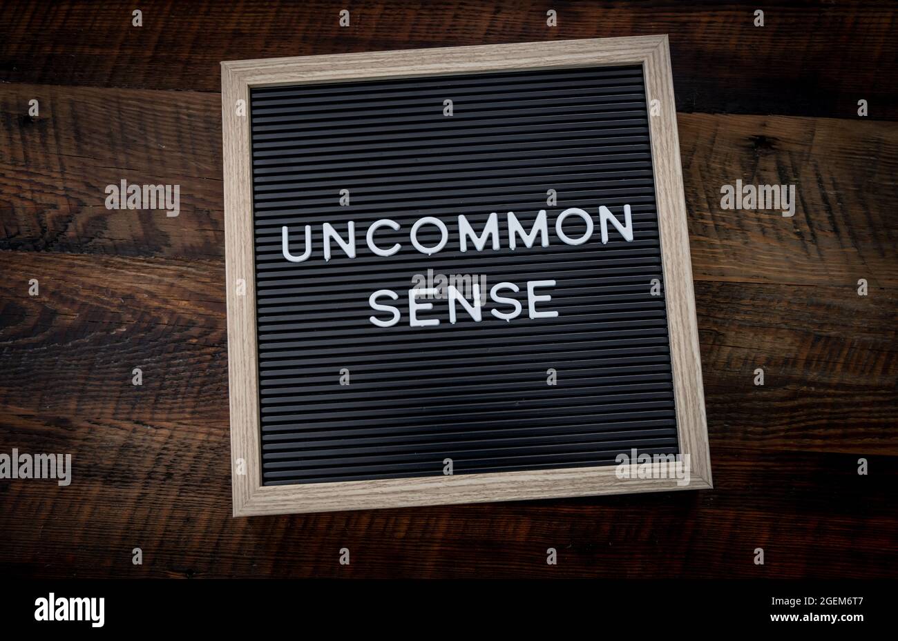 Messaggio di senso non comune su Chalkboard segno su sfondo di legno Foto Stock