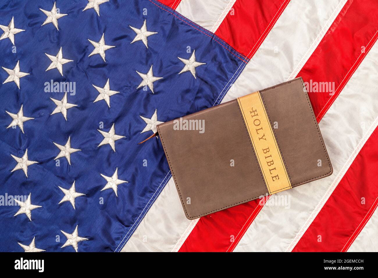 Una bibbia sacra si trova in cima alla bandiera americana degli Stati Uniti, che è emblematica della libertà di religione senza persecuzione. Foto Stock