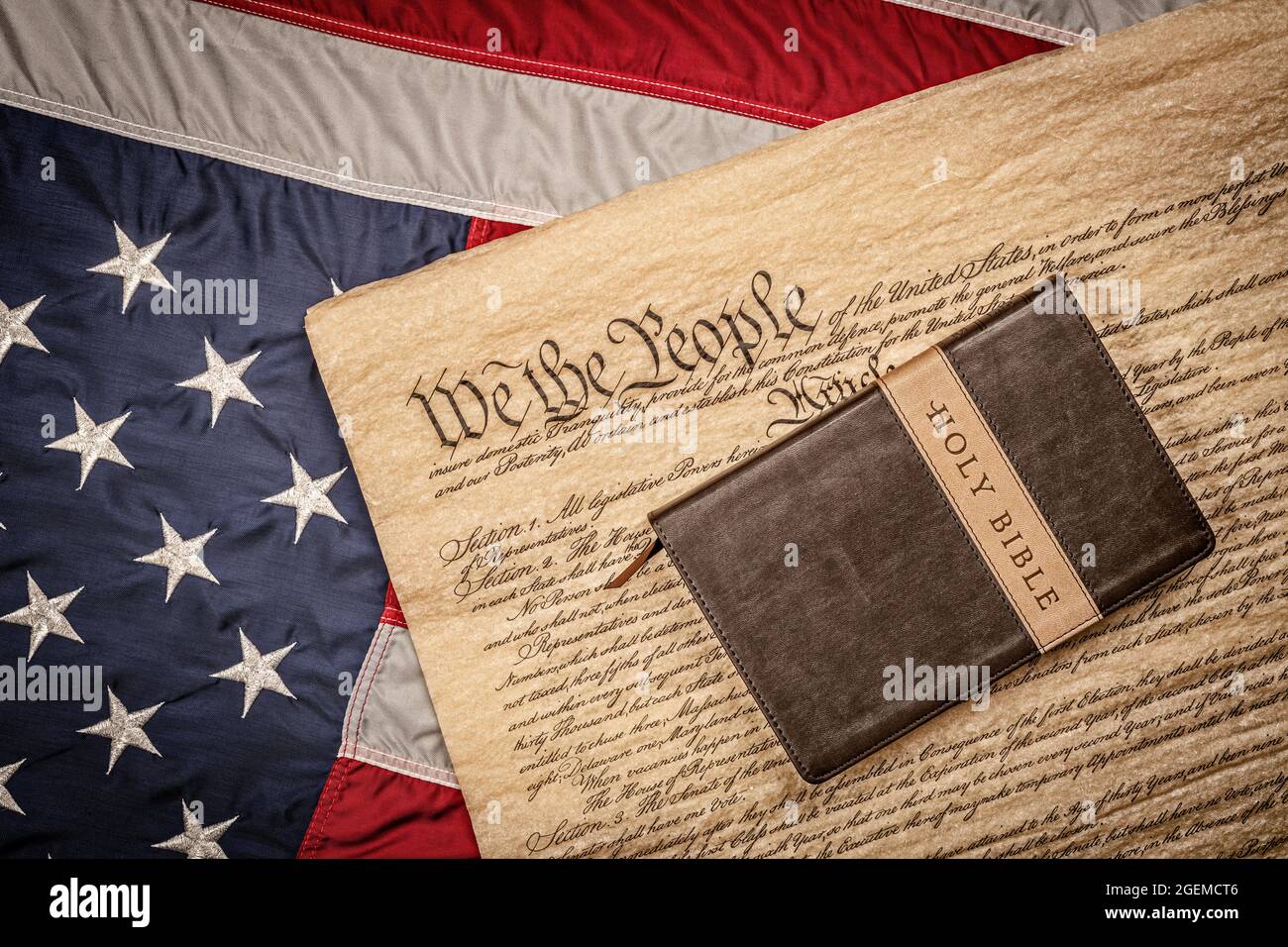 Una bibbia sacra e un crocifisso riposano in cima alla Costituzione degli Stati Uniti e alla bandiera americana, che è emblematica della libertà di religione senza persecuzione. Foto Stock