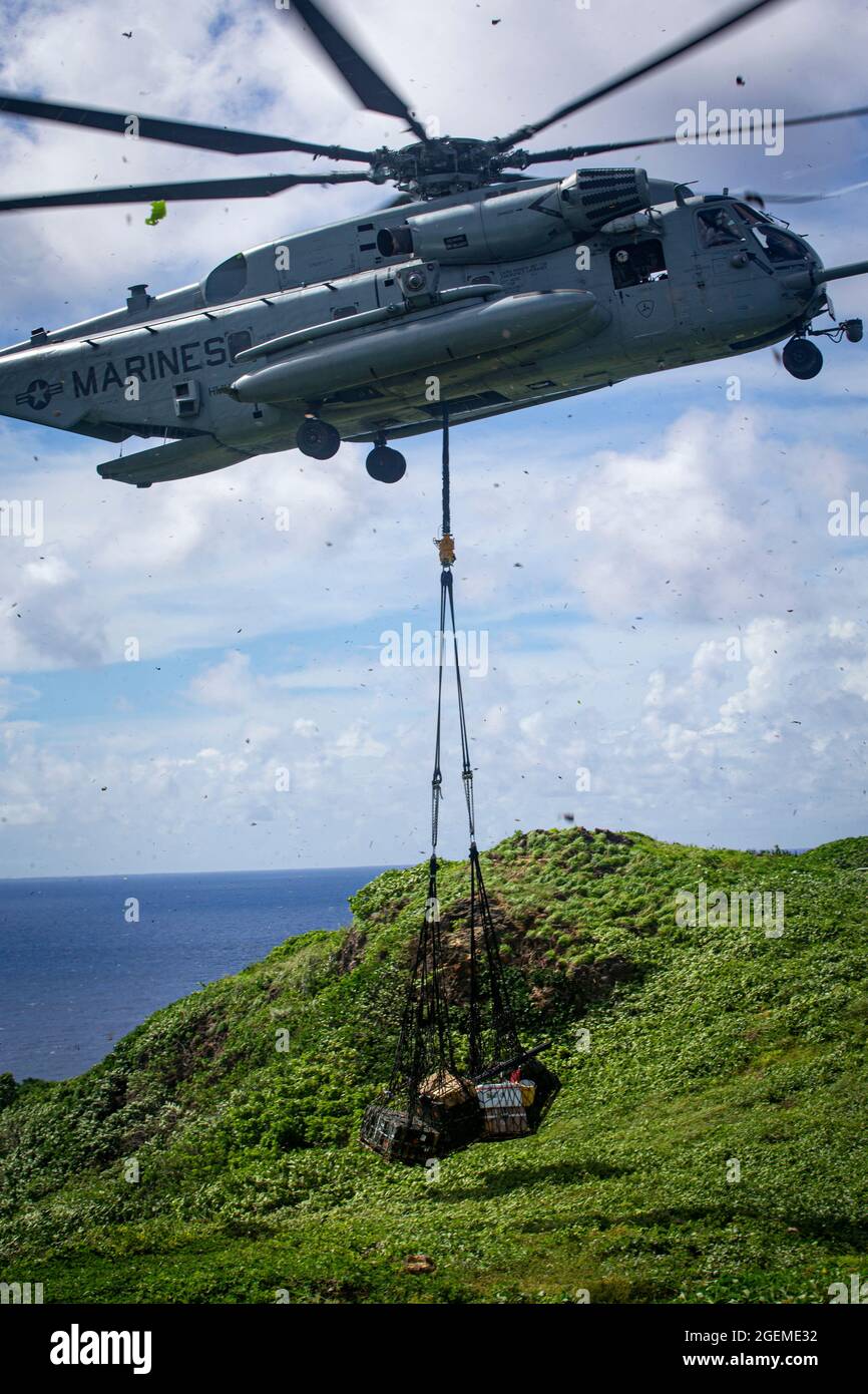 US Marine Corps CH-53E Super Stallion trasporta il carico a Marines con Battalion Landing Team 3/5, 31st Marine Expeditionary Unit (MEU), su Farallon De Medinilla (FDM), per eseguire l'esercizio di coordinamento del supporto antincendio nella catena delle Isole Marianas, 14-15 agosto 2021. Lo scopo dell’esercizio era quello di migliorare la competenza in materia di supporto antincendio, rafforzando al contempo l’interoperabilità con alleati e partner attraverso la condotta di incendi da superficie a superficie, di supporto antincendio navale e di incendi da aria a superficie. Il 31esimo MEU è operativo a bordo di navi dell'America Expeditionary Strike Group nella settima area della flotta dell'Op Foto Stock