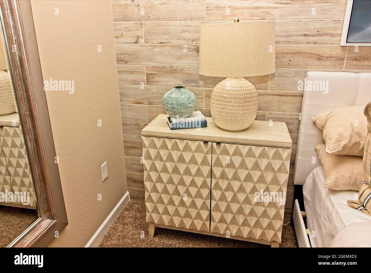 Comodino in legno chiaro con lampada decorativa Foto Stock