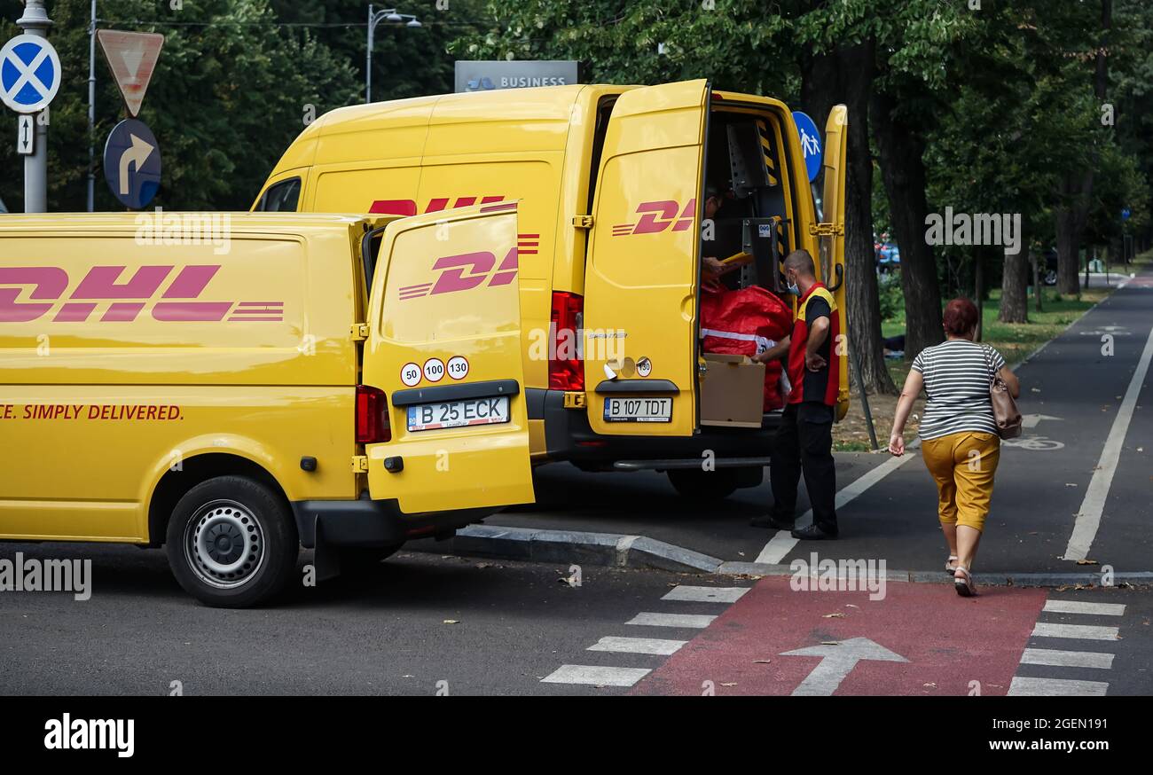 Bucarest, Romania - 20 agosto 2021: Due furgoni gialli DHL di consegna sono visti trasferire i pacchetti su una strada a Bucarest. Questa immagine è per editoria Foto Stock