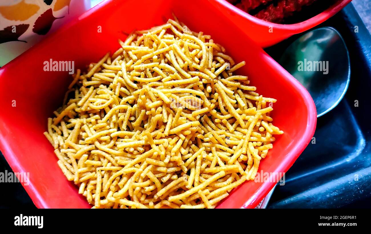 Famoso e amato snack indiano Alo Bhujia fatto di patate, servito in una ciotola rossa. E' il migliore spuntino indiano se servito con bevande. Foto Stock