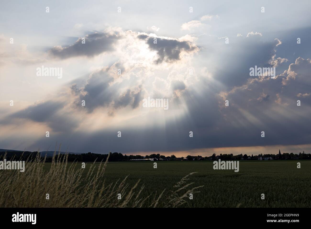 Raggi di luce del sole si infrangono attraverso le nuvole Foto Stock