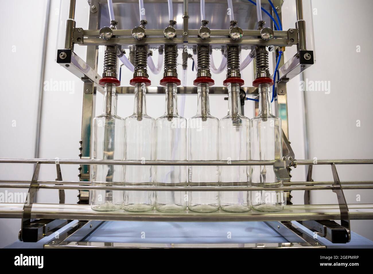 Riempitrice automatica di bottiglie per uso industriale. Foto Stock