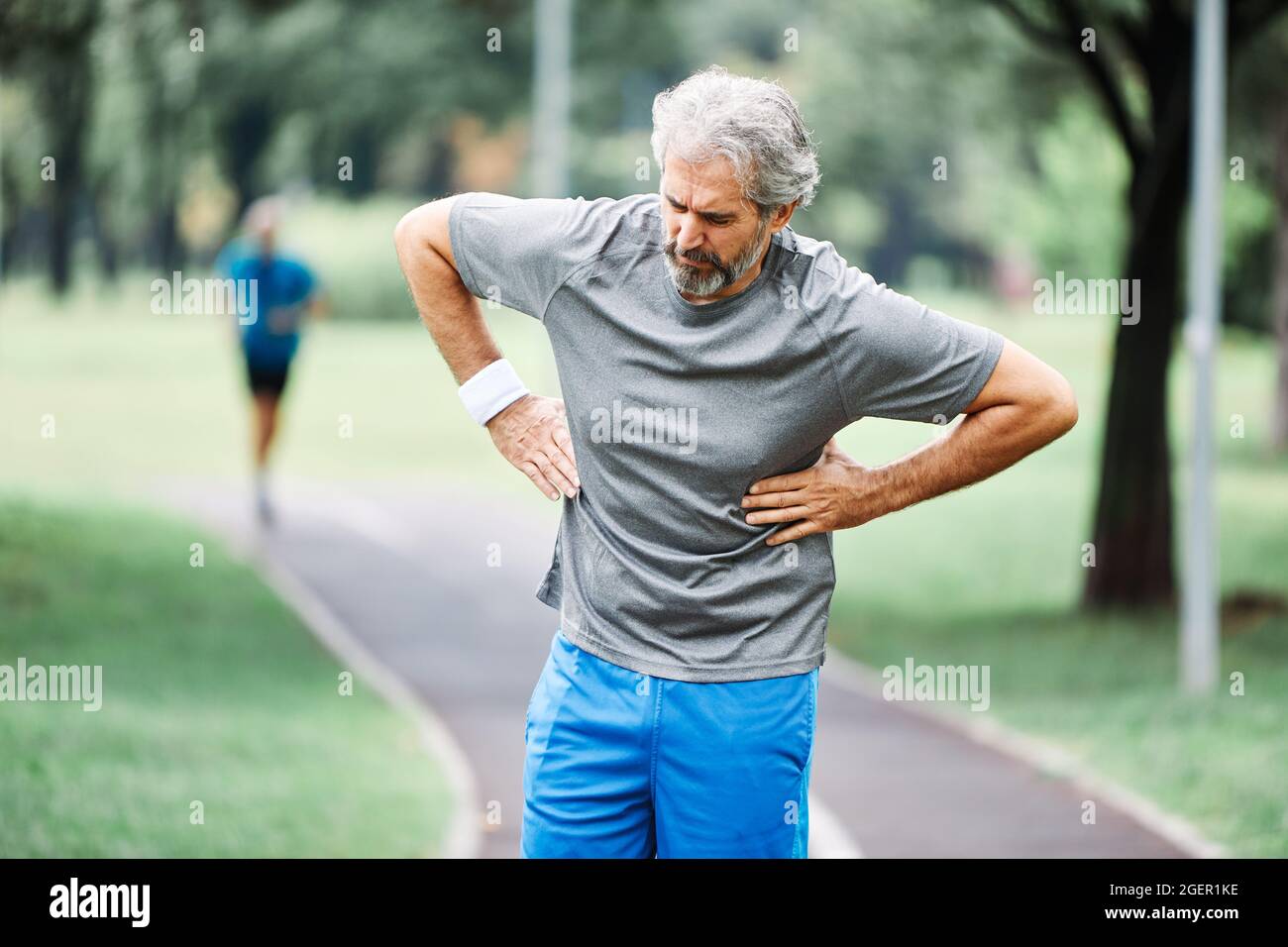 uomo anziano che corre esercitandosi sport fitness petto dolore attacco di cuore Foto Stock