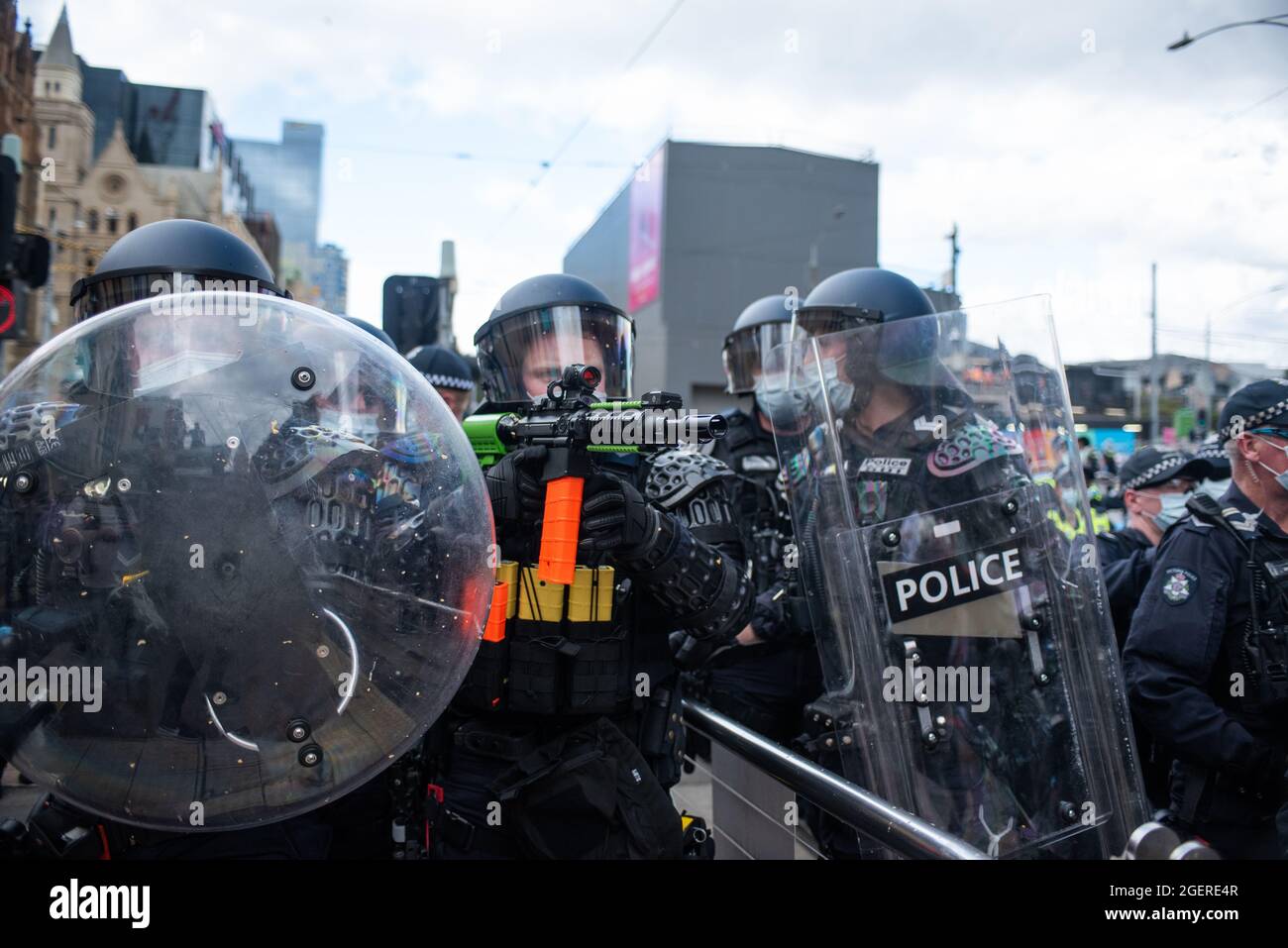 Melbourne, Australia. 21 agosto 2021. Un ufficiale di squadra di sommosse mira a un M4 modificato caricato con i giri di gas lacrimogeni da utilizzare contro i manifestanti anti-blocco. Credit: Jay Kogler/Alamy Live News Foto Stock