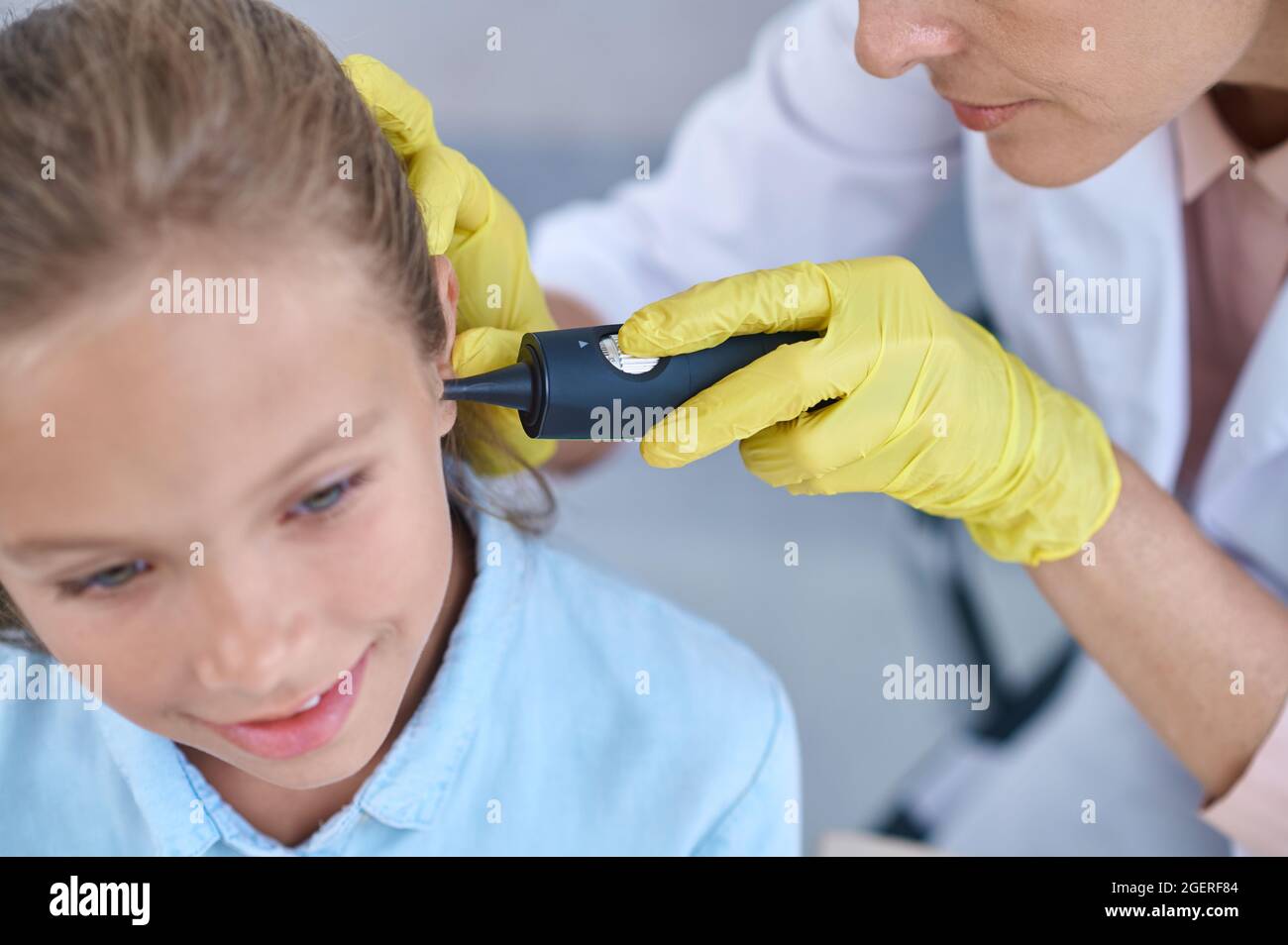 Medico esaminano le ragazze orecchio con dispositivo Foto Stock