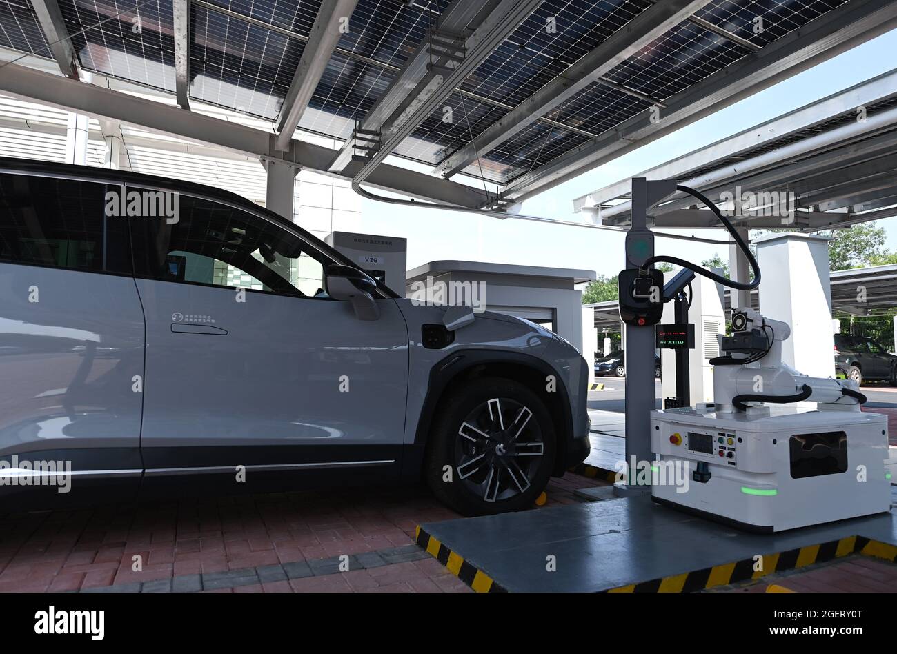 Tianjin. 18 ago 2021. Un robot gestisce un dispositivo di ricarica presso il centro di assistenza integrato Jinmenhu New Energy Vehicle di Tianjin, 18 agosto 2021. Recentemente, è stato messo in uso il Centro di assistenza integrato per veicoli New Energy Jinmenhu. Con un totale di 852 pannelli fotovoltaici disposti sul tetto dell'edificio, il centro servizi dispone di 71 banchi di ricarica, che forniscono cinque modalità di ricarica. La Cina, il mercato automobilistico più grande del mondo, ha visto la sua nuova industria dei veicoli energetici entrare nella corsia di sorpasso, alimentata dalla strategia a basse emissioni di carbonio del paese e dalla crescente domanda. Credit: Li Ran/Xinhua/Alamy Live News Foto Stock